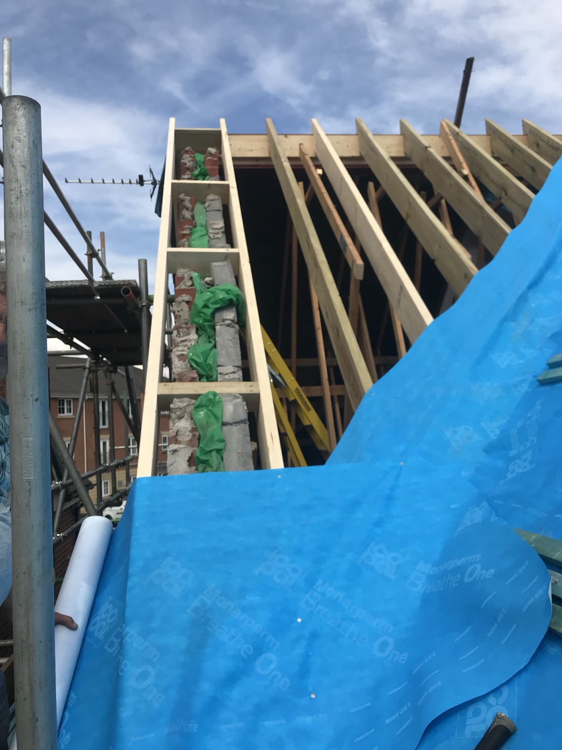 External view of new roof framing and temporary weather protection at Feversham Close