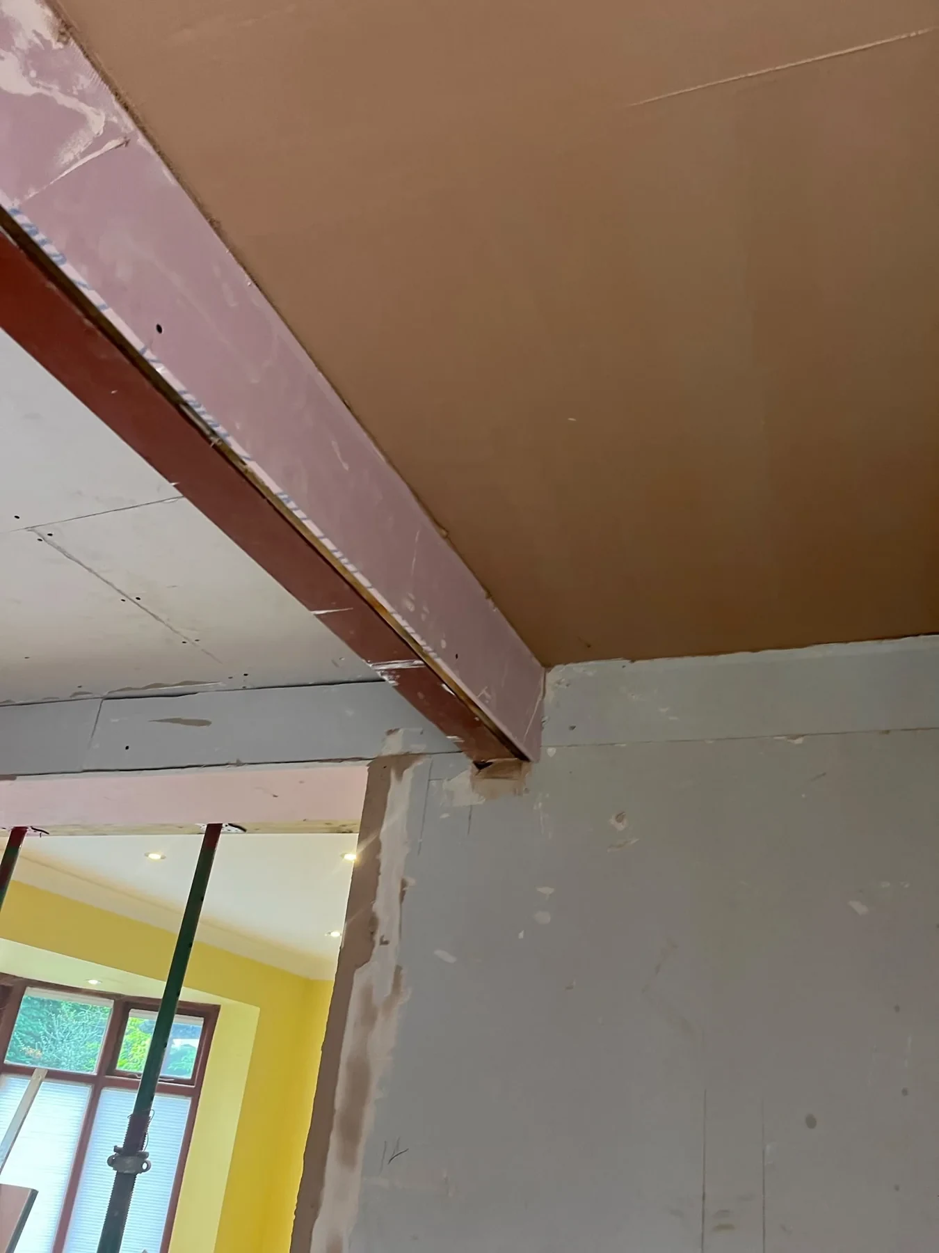 Steel beam visible during ceiling finishing